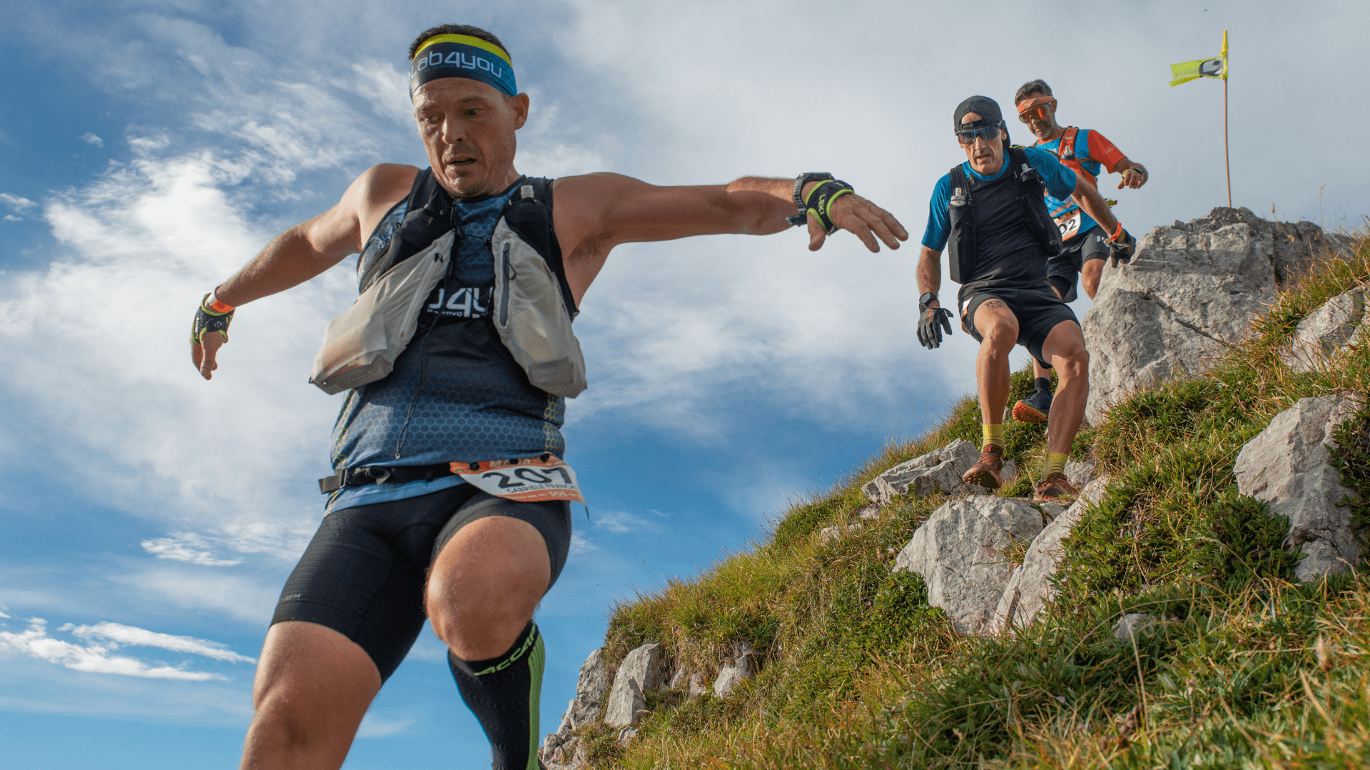Three runners descending a rocky mountain trail